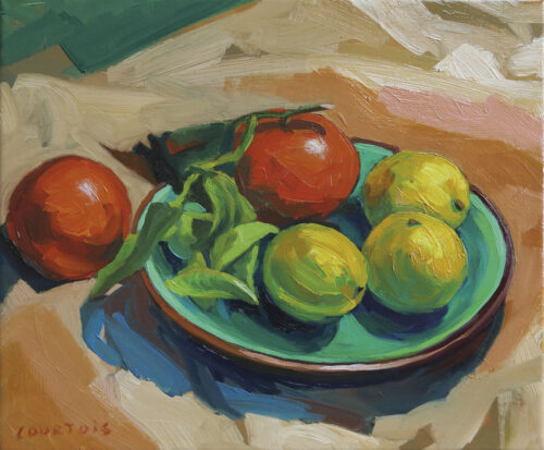 Cinq fruits sur assiette verte Oranges et citrons sur une assiette verte